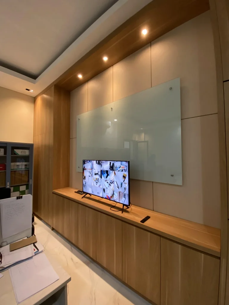 Kabinet TV kantor dengan finishing kayu dan panel dinding dekoratif.