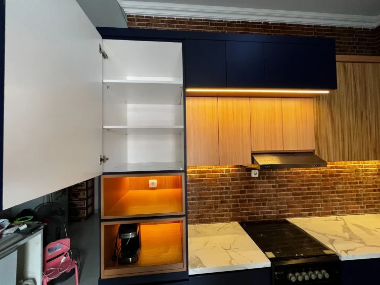 Kitchen set custom dengan kabinet putih dan navy serta area kerja dapur.