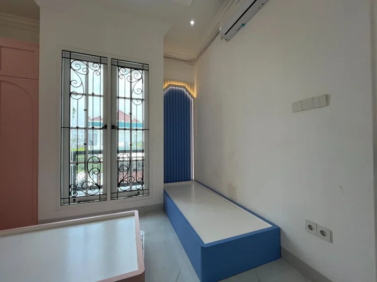 Panel dinding biru dengan bingkai melengkung dekoratif.