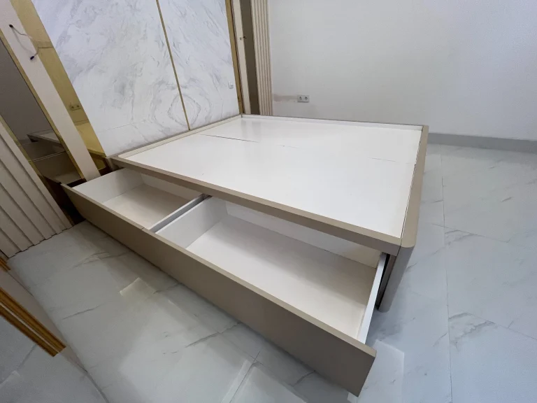Kabinet custom putih dengan permukaan meja dan sudut membulat.
