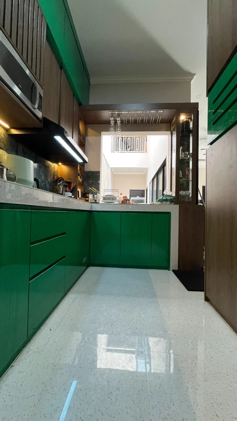 Kabinet bawah kitchen set hijau emerald dengan countertop warna terang.