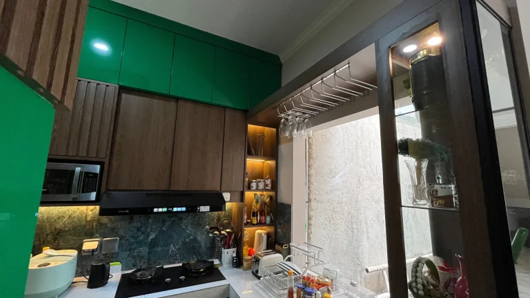 Kitchen set modern hijau dan kayu dengan lampu LED di bawah kabinet.