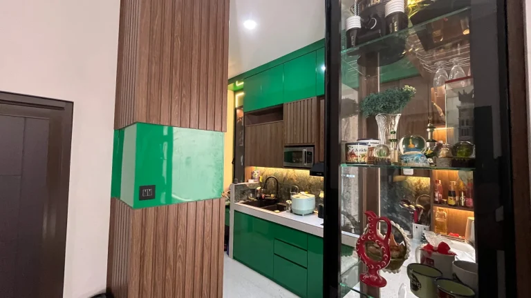 Kabinet atas kitchen set custom dengan finishing motif kayu dan aksen hijau.