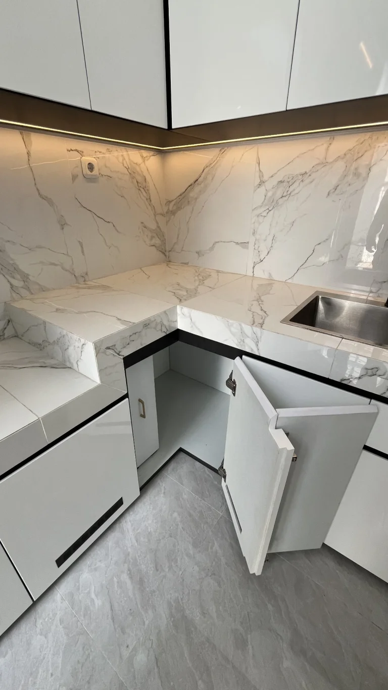 Countertop dapur berbentuk L dengan kabinet bawah putih.