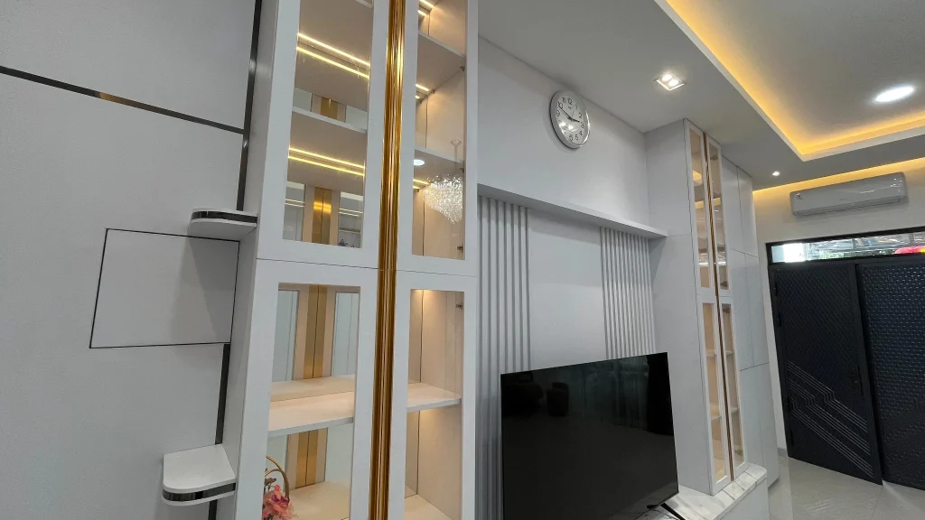 Backdrop TV dengan rak pajangan dan pencahayaan LED terintegrasi.