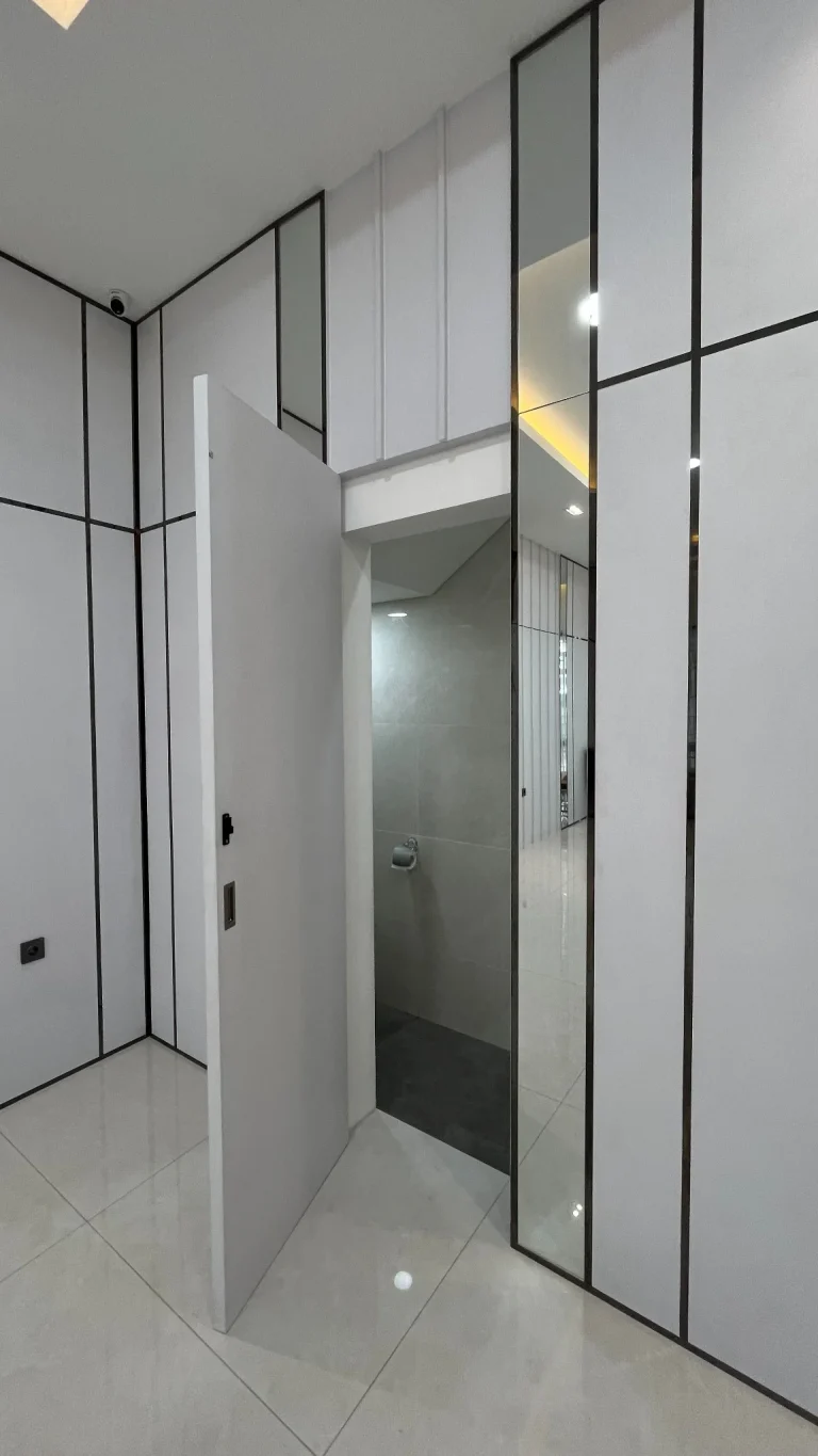 Detail pintu wardrobe custom dengan cermin dan garis vertikal.
