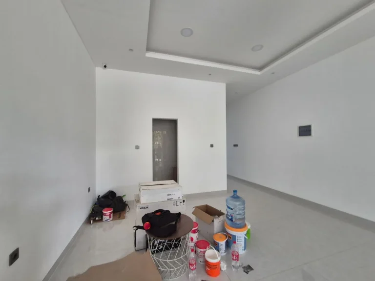 Ruangan berdinding putih yang masih dalam proses penataan interior.